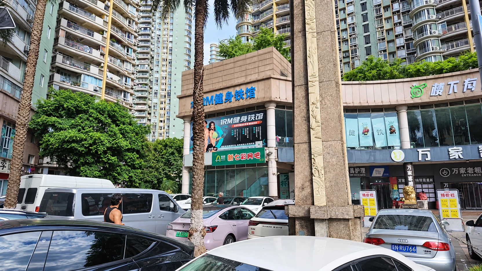 Fachada comercial da 1RM em Chongqing, entre palmeiras, carros e prédios residenciais