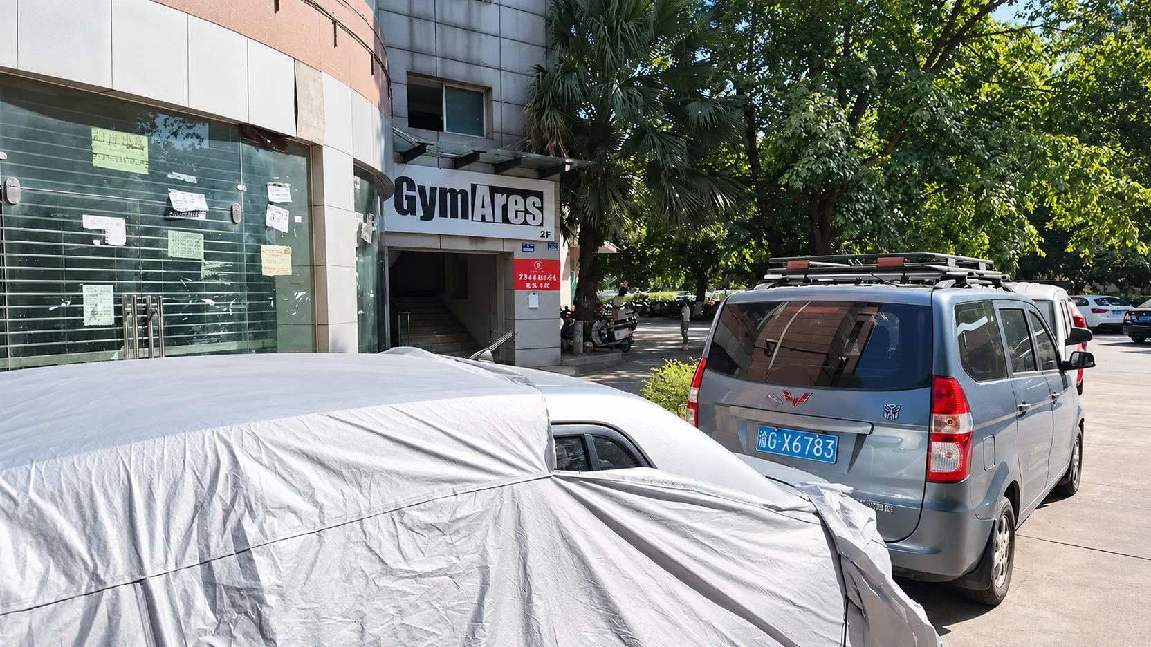 Fachada real com letreiro Gym Ares 2F e acesso por escada em Chongqing